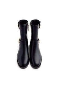 Botines de cuero negro con un acabado suave, punta cuadrada y acentos en hardware dorado, que cuentan con un cierre de cremallera y detalle de hebilla.