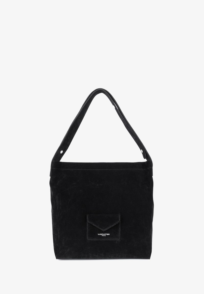 Sac tote en suédine noire avec une poche avant plate, une courte bandoulière et des accents cousus. Présente un petit logo en relief sur la poche.