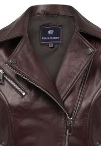 Bordeaux leren jack met een geknipt kraag, ritszakken en zilveren accenten. Binnenkant heeft een stoffen label met de merknaam.