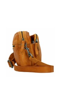 Bolso cruzado de cuero marrón con dos compartimentos con cremallera, correa ajustable y una textura suave. Presenta acentos de hardware en tono plateado.
