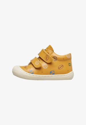 Gelbe Kleinkinderschuhe mit Klettverschlüssen, verziert mit verschiedenen bunten Sportballmustern, weiße strukturierte Gummisohle.