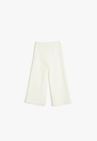 Pantalones de pierna ancha con canalé en blanco roto, con cintura elástica. Textura suave, largo hasta el tobillo sin herrajes ni patrones visibles.