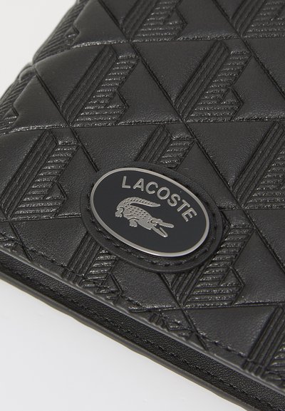 Черен портфейл Lacoste с покритие тип "квадратче" и геометрични шарки, текстурирано синтетично материало и сребърен логотип.