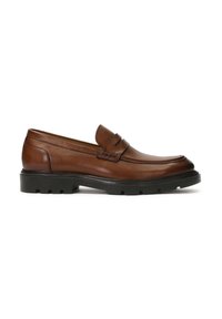 Mocasines de cuero marrón con punta redondeada, costuras decorativas y una suela de goma negra resistente. Presenta un diseño de perfil bajo y estilo de fácil colocación.