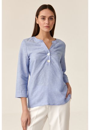 Blusa azzurra chiara a maniche lunghe con scollatura a V, tre bottoni sul davanti e una vestibilità morbida. Il tessuto ha una leggera texture.