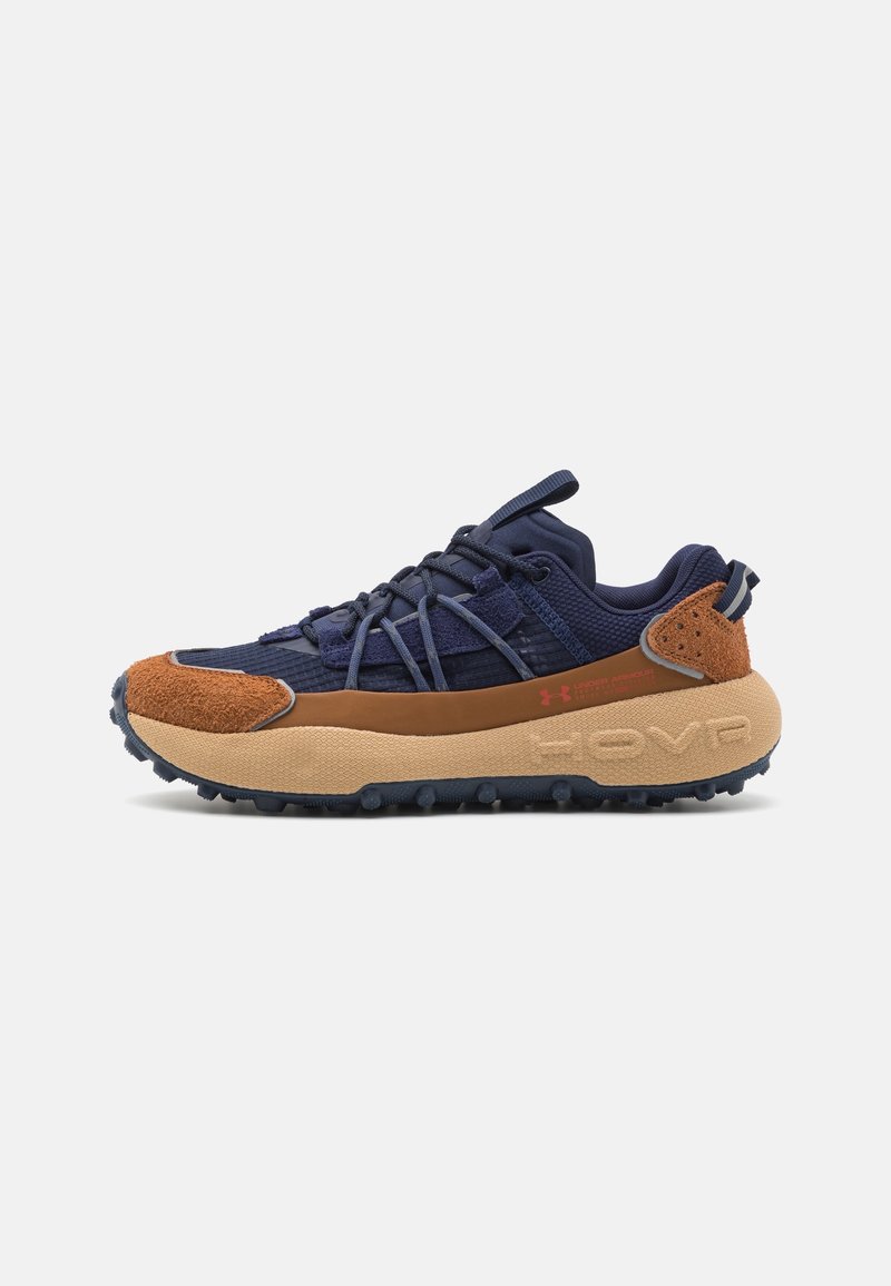 Marine- und braune Trail-Schuhe mit strukturiertem Obermaterial, verstärkten Überzügen und einer auffälligen gepolsterten Sohle mit Profilstollen. Rote Markenakzente.