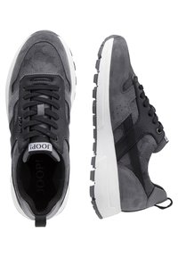 Baskets décontractées grises et noires avec semelles épaisses blanches, lacets à l'avant, et panneaux en tissu texturé et daim, vues de dessus et de côté.