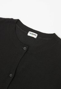 Schwarze gestrickte Strickjacke mit rundem Halsausschnitt, ausgestattet mit einer Knopfverschluss und einem Etikett mit der Aufschrift "TEZENIS KIDS." Weiche Textur und schlichtes Design.