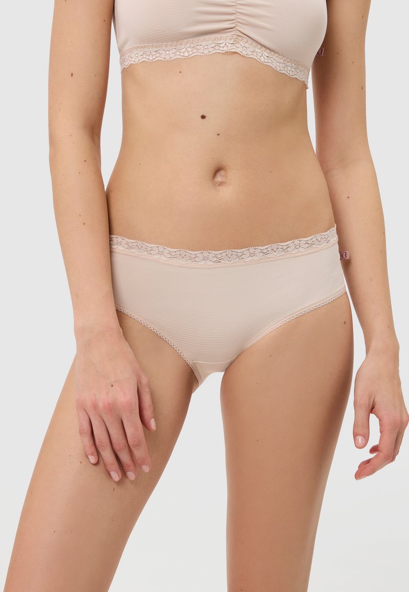 Beige Damenslips aus strukturiertem Stoff, mit einer Spitzenkante entlang des Taillenbunds und glatten, nahtlosen Seiten für optimalen Tragekomfort.