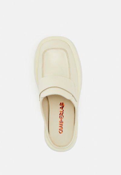 Krämfärgad läderslip-on med rund tå och en vadderad rem. Har kontrasterande orange logotyp på innersulan.