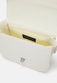 Borsa bianca in pelle sintetica con chiusura magnetica, dotata di un interno in tessuto giallo e di un'etichetta nera. Design rettangolare semplice.