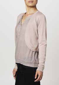 Ljusrosa cardigan med långa ärmar, en draperad framdel och ett texturerat stickat mönster. Har en dragen nederkant för en figurnära look.