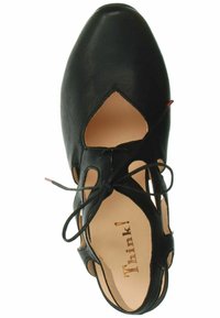 Scarpa in pelle nera con design a intaglio, punta affusolata e lacci incrociati. Presenta una fodera beige e un logo discreto all'interno.