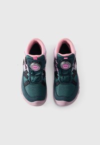 Een paar groene en roze sportschoenen met BOA-draaisluiting, gezien van bovenaf tegen een effen witte achtergrond.