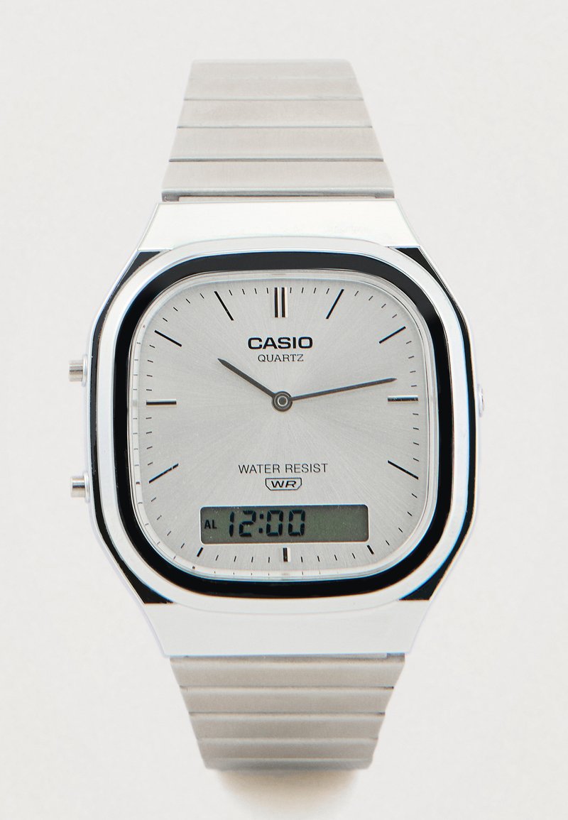 Ασημένιο ρολόι Casio quartz με ορθογώνιο καντράν, αναλογικές και ψηφιακές ενδείξεις, μπρασελέ από ανοξείδωτο ατσάλι και σήμανση αντοχής στο νερό.