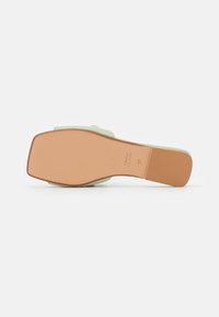 Sandal con tacco color verde menta, con una parte superiore texture, punta quadrata e una suola liscia di color marrone chiaro. Taglia 37 indicata sulla suola.