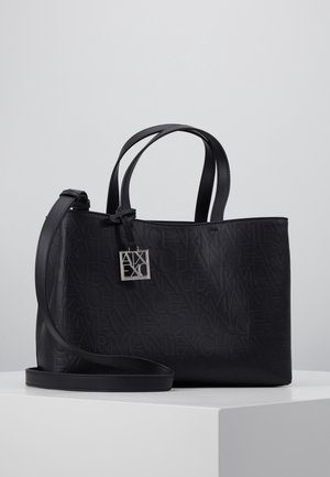 Bolso de cuero negro con el texto en relieve "ARMANI EXCHANGE", doble asa, correa ajustable para el hombro y un colgante cuadrado de plata con la marca.