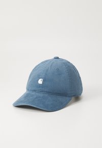 Boné de baseball em veludo cotelê azul com uma aba curva, superfície texturizada e um pequeno logo branco na frente.