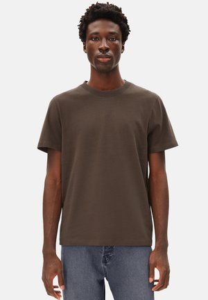 Bruine katoenen T-shirt met een ronde halslijn, ontspannen pasvorm, korte mouwen en een gladde textuur, gecombineerd met blauwe spijkerbroeken.