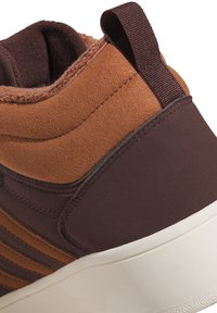 Braune und dunkelbraune High-Top-Sneaker aus Wildleder und strukturierten synthetischen Materialien, mit gepolstertem Schaft und einer weißen Gummisohle.