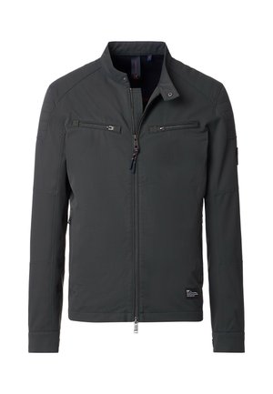La chaqueta gris presenta un collar elevado, dos bolsillos en el pecho con cremallera y detalles panelados en los hombros. Está hecha de una tela suave y duradera.
