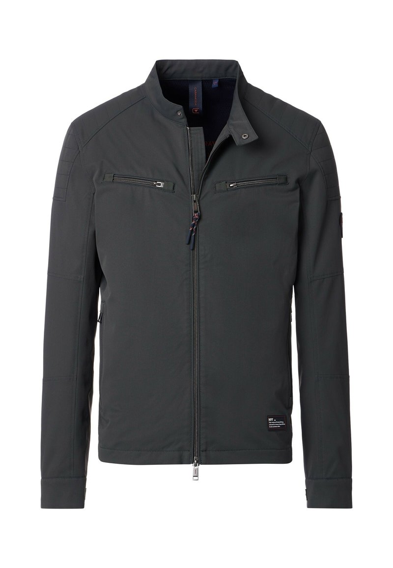 La chaqueta gris presenta un collar elevado, dos bolsillos en el pecho con cremallera y detalles panelados en los hombros. Está hecha de una tela suave y duradera.
