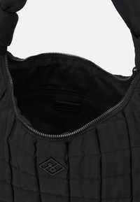 Bolso de hombro negro acolchado con cierre de cremallera, que cuenta con un bolsillo interior con cremallera y un exterior texturizado. Acentuado con un parche de logo.