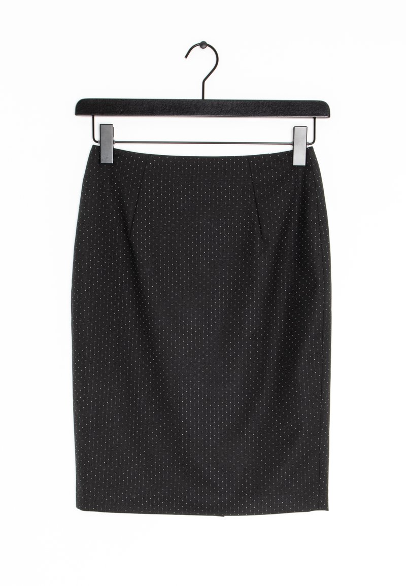 Jupe crayon noire avec de fines rayures blanches verticales suspendue sur un cintre noir sur fond blanc.