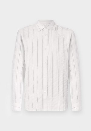 Chemise blanche à boutons, en tissu texturé, avec de fines rayures noires verticales, un col classique et des manches longues avec des poignets à boutons.