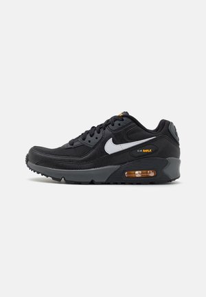 Czarny sneaker Nike Air Max 90 z fakturowaną cholewką, szarymi akcentami, białym logo i widoczną jednostką amortyzującą powietrzną w pięcie.