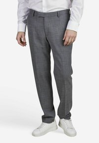 Pantalons à carreaux gris en tissu tissé, avec une coupe droite et une taille standard. Associés à des baskets blanches.