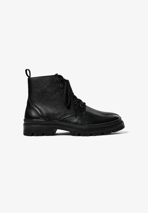 Bottes de cheville en cuir noir avec une finition texturée, dotées d'un système de laçage, d'un tirant et d'une semelle en caoutchouc robuste pour une meilleure adhérence.