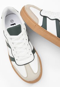 Sneakers bianchi con accenti verdi e beige, caratterizzati da una tomaia in pelle liscia, sezioni in suede testurizzato e una suola in gomma. Taglia 37.