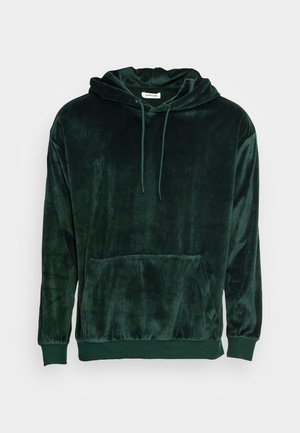 Sweat à capuche en velours vert foncé avec poche avant, capuche à cordon de serrage et poignets et ourlet côtelés, présenté sur un fond clair uni.