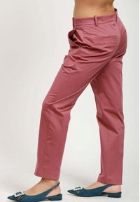 Rosa skräddarsydda byxor med en slät textur, mellan hög midja och sidofickor, kombinerat med blå slingback-sandaler med dekorationer.