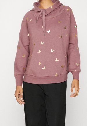 Fliederfarbener Hoodie mit Kordelzugkragen und goldenen Schmetterlingsmotiven, getragen mit schwarzen Hosen, gezeigt vom Hals bis zu den Hüften.