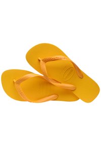 Yellow flip-flops made of rubber with textured soles, featuring thin straps and embossed brand logo on one strap.