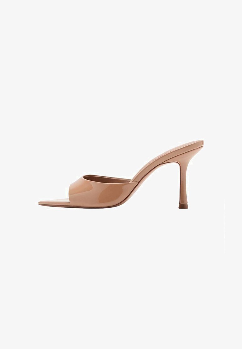 Mules à talons hauts en cuir verni couleur nude, avec une tige lisse et incurvée et un bout ouvert. Caractéristiques : talon aiguille et design minimaliste.