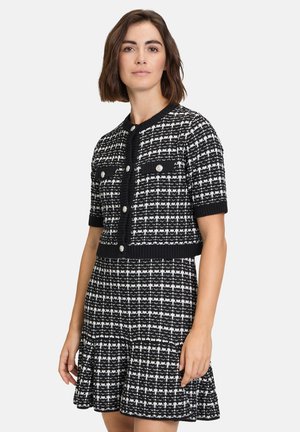 Schwarz-weißes Tweed-Kleid mit kurzen Ärmeln, runden Ausschnitt, durchgeknöpftem Vorderteil und ausgestellt Rock mit strukturierter Musterung.