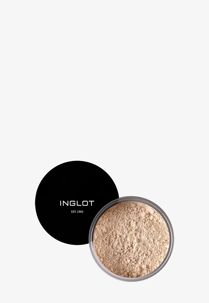 Poudre libre dans un pot transparent, couleur beige clair, avec un couvercle noir affichant "INGLOT EST. 1983" en texte blanc. Texture fine.