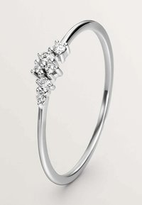 Anillo de plata con una banda lisa y cinco diamantes redondos agrupados de diferentes tamaños, engastados en un metal pulido.