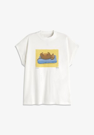 Biele tričko s ilustráciou hnedého psa ležiaceho na chrbte na modrom vankúši so žltým pozadím.