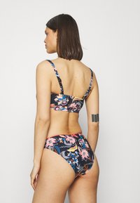 Ensemble de bikini fleuri avec un fond sombre, des fleurs multicolores, des bretelles fines et un bas à taille moyenne ; tissu lisse avec une coupe ajustée.