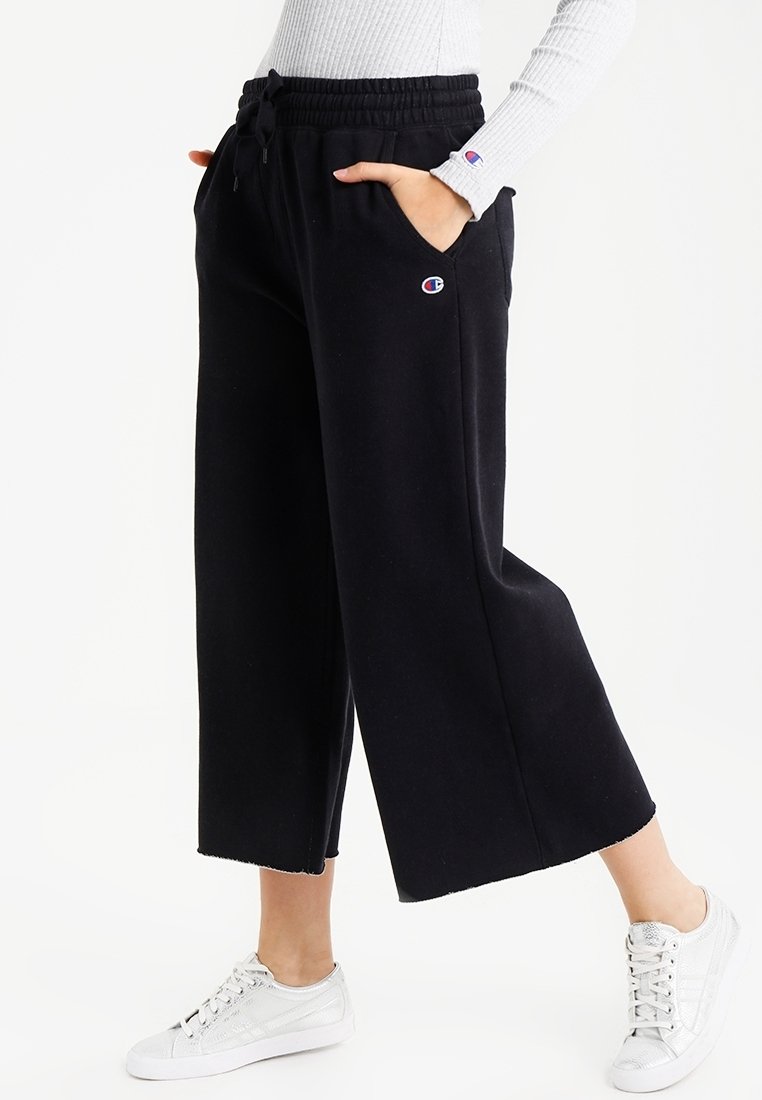 Sorte, brede sweatpants med snor i taljen, sidelommer og broderet logo. Stoffet er blødt og struktureret.