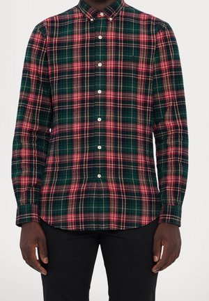 Camisa de cuadros verde y marino con acentos en rojo y crema, de mangas largas, con cuello abotonado y botones en la parte delantera. Tejido de algodón.