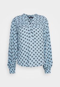 Blouse à manches longues de couleur bleu clair avec un motif floral bleu marine, dotée d'un col plissé et d'une fermeture à boutons à l'avant. Tissu doux et léger.