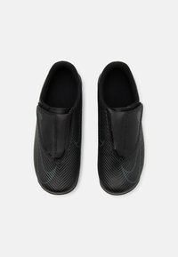Melnas slip-on kurpes ar teksturētu oglekļa šķiedras dizainu un subtilām zila akcentiem; gluda iekšējā oderējuma bez redzamām metalizētām daļām.