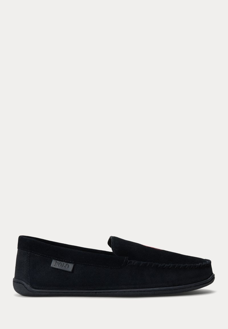 Chausson style mocassin en daim noir avec semelle en caoutchouc et une petite étiquette de la marque Polo sur le côté.