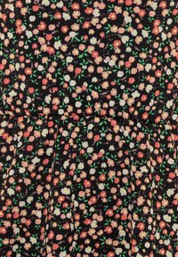 Mustaa kangasta, jossa on kukkakuosi, joka esittää pinkkejä, valkoisia ja vihreitä kukkia. Kankaan pinnassa on hieman poimuttunut rakenne ja laskostettuja yksityiskohtia.