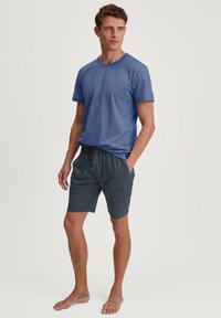 Blauwe katoenen t-shirt voor heren, gecombineerd met gestreepte marineblauwe shorts met een trekkoord in de taille en een subtiel geometrisch design.